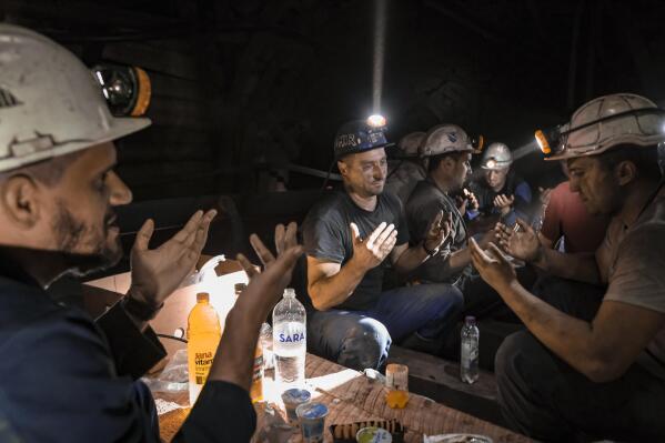 Bosnian coal miners pray after breaking fast in the underground at a mine in Zenica, Bosnia, Thursday, April 29, 2021. Inside mine shafts, one can't see sunset, but miners consult their watches and smartphones for the right time to sit down, unwrap their food and break their daily fast together. (AP Photo/Kemal Softic)