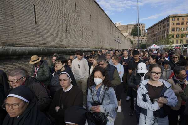 People wait in line to view Pope Francis lying in state inside St. Peter's Basilica, at the Vatican, Thursday, April 24, 2025. (AP Photo/Markus Schreiber)
