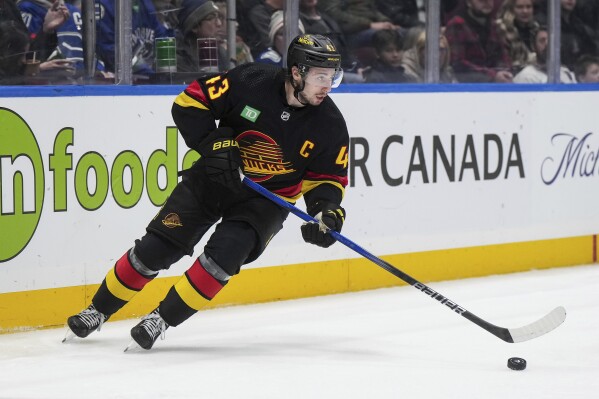 Vancouver Canucks' Quinn Hughes skates with the puck during the second period of an NHL hockey game against the San Jose Sharks in Vancouver, British Columbia, Monday, Nov. 20, 2023. (Darryl Dyck/The Canadian Press via AP)