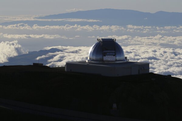 FILE - In this July 14, 2019, file photo, a telescope at the summit of Mauna Kea, Hawaii's tallest mountain is viewed. Astronomers across 11 observatories on Hawaii’s tallest mountain have cancelled more than 2,000 hours of telescope viewing over the past four weeks because a protest blocked a road to the summit. Astronomers said Friday, Aug. 9, 2019, they will attempt to resume observations but in some cases won’t be able to make up the missed research. (AP Photo/Caleb Jones, File)