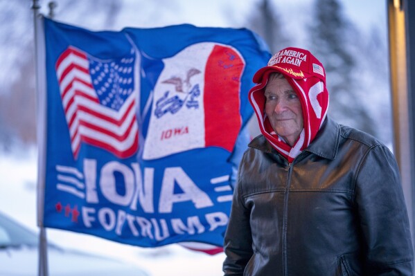 File - A man stands near a flag that reads "iowa for trump" Outside the machine shed in Urbandale, Iowa, Jan. 11, 2024.  Voters in Iowa will participate in caucuses on Monday, January 15, which will begin the GOP presidential nominating process.  (AP Photo/Andrew Harnik, File)