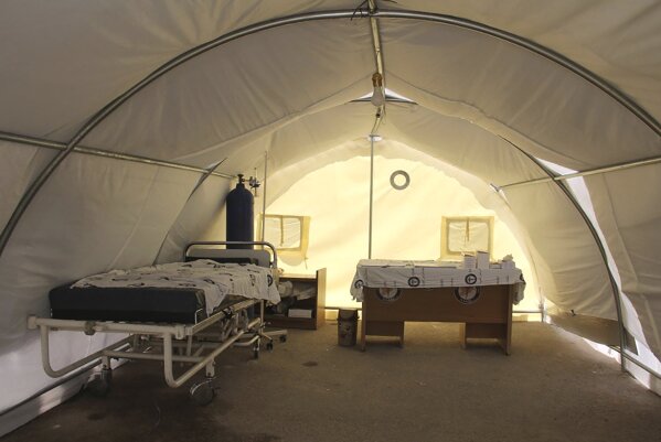 This photo provided on April 12, 2020, by the Syrian American Medical Society, which has been authenticated based on its contents and other AP reporting, shows a hospital bed and medical equipment in a tent outside Idlib Central Hospital that is used to check patients for fever and other symptoms as part of the effort to contain and trace the coronavirus, in Idlib, northern Syria. Nine years of war have broken Syria into three rival parts, and each is struggling to cope with a common enemy that knows no conflict lines. Unable to work together, their divisions are hurting frantic efforts to mobilize against the coronavirus in a country where the health sector is already devastated by war. (Syrian American Medical Society via AP)