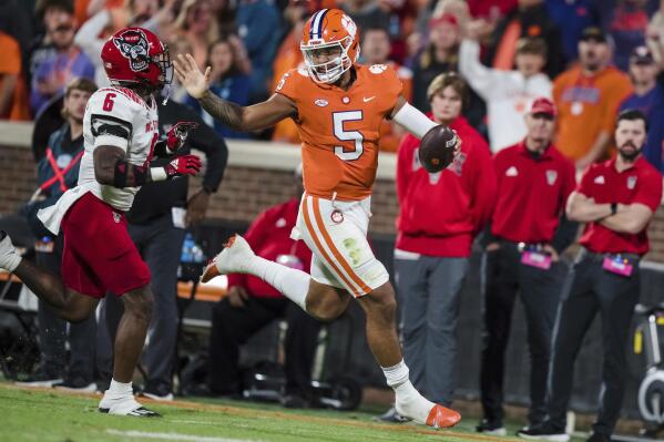 Clemson quarterback DJ Uiagalelei (5) runs with the ball while pursued by North Carolina State safety Jakeen Harris (6) in the second half of an NCAA college football game, Saturday, Oct. 1, 2022, in Clemson, S.C. (AP Photo/Jacob Kupferman)