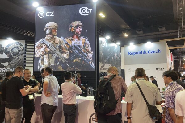 People gather around the booth of Colt, an American firearm manufacturer, on display at the Defense Services Asia (DSA) exhibition in Kuala Lumpur, Malaysia Tuesday, May 7, 2024. (AP Photo/Syawalludin Zain)