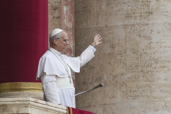 Pope Leo XIV appears at the central balcony of St. Peter's Basilica for his first Sunday blessing after his election, in St. Peter's Square at the Vatican, Sunday May 11, 2025. (AP Photo/Domenico Stinellis)