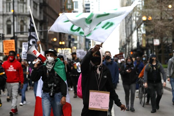 Protestors proceed along Chicago downtown during a peaceful protest on Tuesday, April 13, 2021, demanding justice for Daunte Wright, a 20-year-old Black man who was shot dead by police Sunday after a traffic stop in Brooklyn Center, Minn. (AP Photo/Shafkat Anowar)