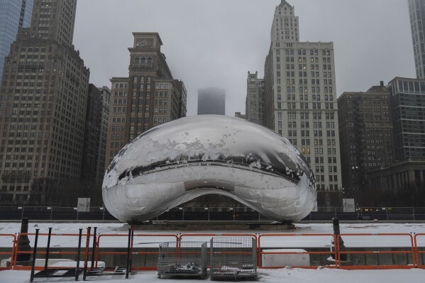 Snow covers the Cloud Gate sculpture in Millennium Park after a winter storm, Friday, Jan. 12, 2024, in Chicago. (AP Photo/Erin Hooley)