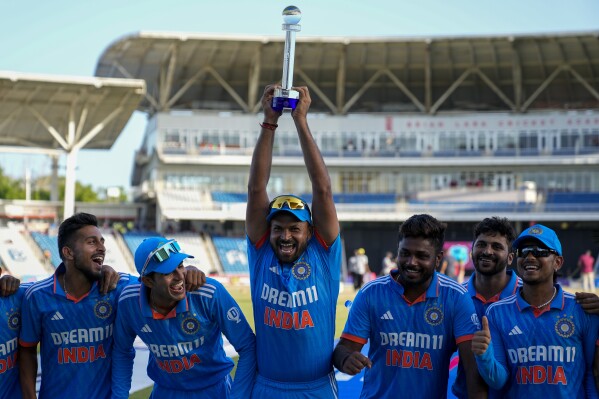 India's Mukesh Kumar hoist the trophy after India defeated West Indies for 200 runs in their third ODI cricket match to win the series 2-1 at the Brian Lara Stadium in Tarouba, Trinidad and Tobago, Wednesday, Aug. 2, 2023. (AP Photo/Ramon Espinosa)