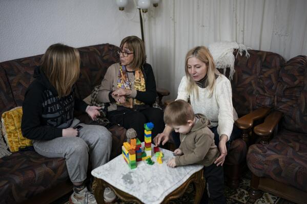 FILE - Ukrainian refugees sit in a home of a resident in the village of Guissona, Lleida, Spain, Thursday, March 17, 2022. More than a year after Russia’s invasion, thousands of Ukrainians who fled to Spain are still waiting for promised direct payments of 400 euros ($425) a month in the regions where most of them live. (AP Photo/Joan Mateu Parra, File)