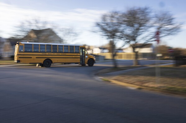 A diesel school bus turns a corner on its way to school in Virginia Beach, Virginia, on Tuesday, Feb. 6, 2024.  Diesel exhaust from school buses affects one-third of America's students, their parents, and teachers every day.  (AP Photo/Tom Brenner)