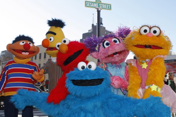 FILE - Characters from Sesame Street Live appear on the street by Madison Square Garden in New York, Feb. 10, 2010. MacArthur Foundation will donate $100 million to the winner of its 100&Change competition. The first 100&Change challenge was awarded in 2017 to a collaboration between Sesame Workshop and the International Rescue Committee to provide educational programming to refugee children in the Middle East. (AP Photo/Kathy Willens, File)