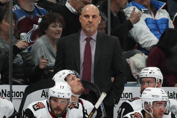 FILE - In this March 29, 2019, file photo, Arizona Coyotes head coach Rick Tocchet, center top, looks on in the second period of an NHL hockey game against the Colorado Avalanche in Denver. The Coyotes and Tocchet have mutually agreed to part ways after four seasons. The announcement Sunday, May 9, 2021, comes a day after the Coyotes missed the playoffs for the seventh time in eight seasons. (AP Photo/David Zalubowski, File)