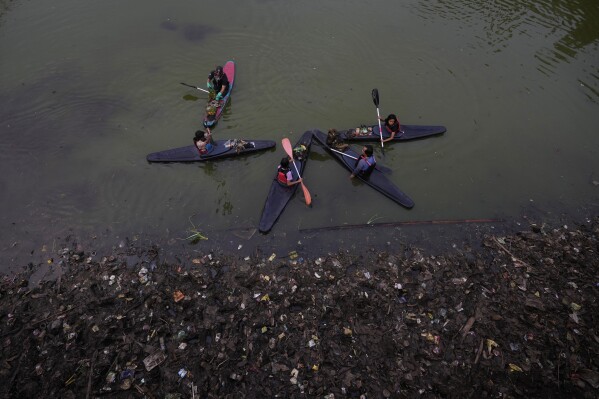 Members of the group Situ Gede Cleanliness Warrior pick up trash at Setu Gede lake in Bogor, West Java, Indonesia, Tuesday, Oct. 10, 2023. Young people have been at the forefront of environmental and climate change movements in the recent years: initiatives like school strikes for climate action, protests at United Nations climate talks and around the world and local clean ups have often been youth-led. (AP Photo/Achmad Ibrahim)