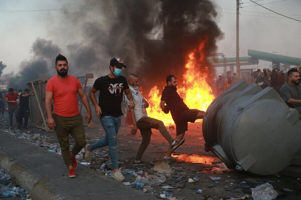 Anti-government protesters set fires and close a street during a demonstration in Baghdad, Iraq, Thursday, Oct. 3, 2019. Iraqi security forces fired live bullets into the air and used tear gas against a few hundred protesters in central Baghdad on Thursday, hours after a curfew was announced in the Iraqi capital on the heels of two days of deadly violence that gripped the country amid anti-government protests that killed over several in two days. (AP Photo/Hadi Mizban)