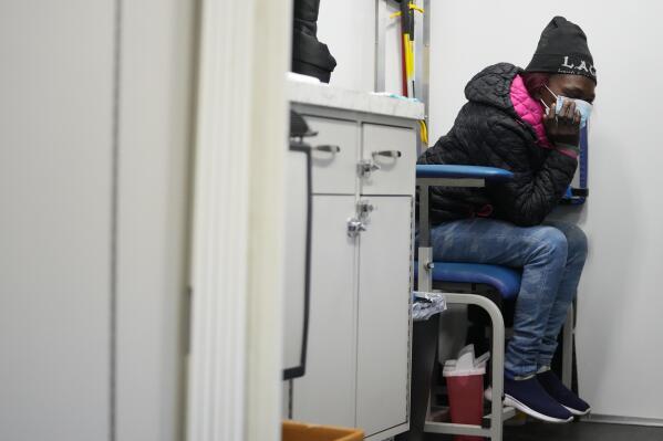 A woman sits before being treated inside a Baltimore City Health Department RV, Monday, March 20, 2023, in Baltimore. The Baltimore City Health Department's harm reduction program uses the RV to address the opioid crisis, which includes expanding access to medication assisted treatment by deploying a team of medical staff to neighborhoods with high rates of substance abuse and offering buprenorphine prescriptions. (AP Photo/Julio Cortez)