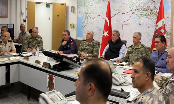 Turkey's Defense Minister Hulusi Akar, center, sits with Turkish army's top commanders in an operation room at the army headquarters, in Ankara, Turkey, Wednesday, Oct. 9, 2019. Turkey's Defense Ministry says Turkish ground forces have moved across the border to fight against Kurdish fighters in northeastern Syria, hours after Turkish jet and artillery pounded areas in Syria's northern border. (Turkish Defence Ministry via AP, Pool)