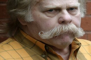 FILE - In this June 10, 2013 file photo, University of Alabama fan Harvey Updyke departs the Lee County Justice Center in Opelika, Ala., after pleading guilty earlier to poisoning landmark oak trees at Auburn University. Updyke has died. He was 71. (AP Photo/Dave Martin, File).