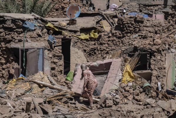 A woman tries to recover some of her possessions from her home which was damaged by the earthquake in the village of Tafeghaghte, near Marrakech, Morocco, Monday, Sept. 11, 2023.  (AP Photo/Mosa'ab Elshamy)