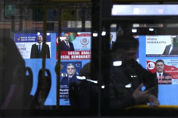 Election posters of all Azerbaijani presidential candidates are seen via bus windows in Baku, Azerbaijan, Monday, Feb. 5, 2024. Azerbaijan will hold presidential elections on Wednesday, Feb. 7. (AP Photo/Sergei Grits)