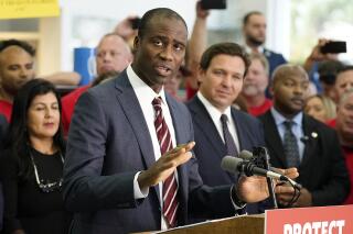 FILE - Florida Surgeon General Dr. Joseph Ladapo gestures as speaks to supporters and members of the media before a bill signing by Gov. Ron DeSantis on Nov. 18, 2021, in Brandon, Fla. A former supervisor of Ladapo declined to recommend him to lead the state's health department during a background check, records show. Ladapo, appointed in September by DeSantis, has drawn scrutiny over his alignment with the governor in resisting coronavirus vaccine mandates and other virus policies embraced by federal health officials. (AP Photo/Chris O'Meara, File)