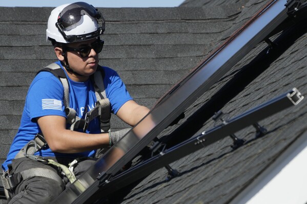 A technician installs solar panels on a roof of a home in Arlington Heights, Ill., Monday, Feb. 26, 2024. On Wednesday, March 6, 2024, the Labor Department reports on job openings and labor turnover for January. (AP Photo/Nam Y. Huh)