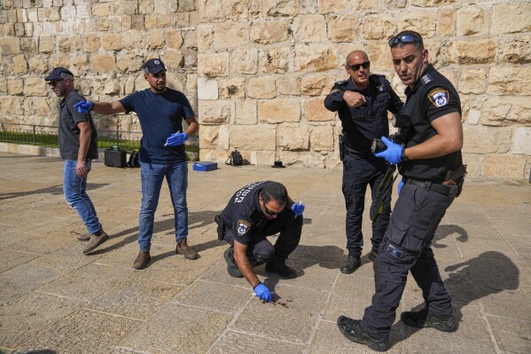Israeli police inspect the scene of a Palestinian stabbing attack that wounded two people next to Jaffa Gate, just outside Jerusalem's Old City, Wednesday, Sept. 6, 2023. Israeli police said the attacker, 17-year-old Palestinian, was caught and arrested. (AP Photo/Ohad Zwigenberg)