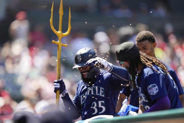 Seattle Mariners' Eugenio Suarez holds a trident while celebrating his home  run with Julio Rodriguez, right, in a baseball game against the Los Angeles  Angels, Tuesday, Sept. 12, 2023, in Seattle. (AP