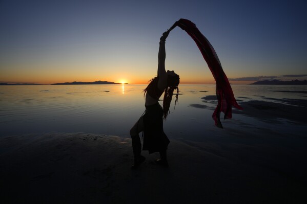 Kelsey Isis performs during a gathering of dancers and performers at sunset on the shoreline of the Great Salt Lake on June 15, 2023, in Magna, Utah. People are rejoicing after the winter's snow melted and increased the lake's elevation beyond last year's record low. (AP Photo/Rick Bowmer)