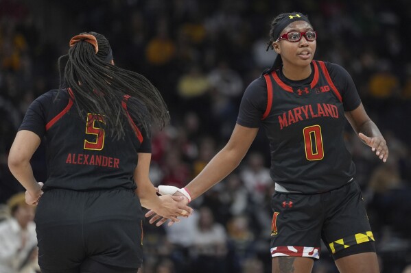 Maryland guards Brinae Alexander (5) and Shyanne Sellers (0) high-five during the first half of an NCAA college basketball quarterfinal game against Ohio State at the Big Ten women's tournament Friday, March 8, 2024, in Minneapolis. Maryland upsets No. 3 Ohio State 82-61. (AP Photo/Abbie Parr)