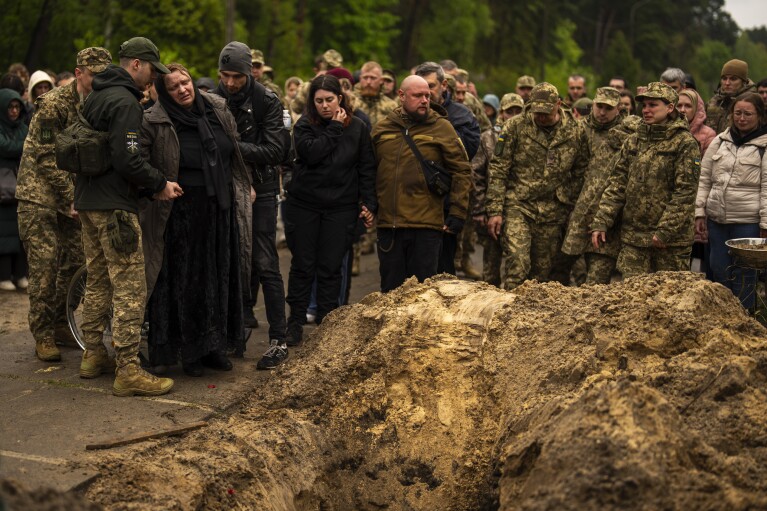 Family, friends and army comrades gather to mourn Ukrainian army paramedic Nazarii Lavrovskyi, 31, killed in the war, during his funeral ceremony at Lisove cemetery in Kyiv, Wednesday, April 24, 2024. (AP Photo/Francisco Seco)
