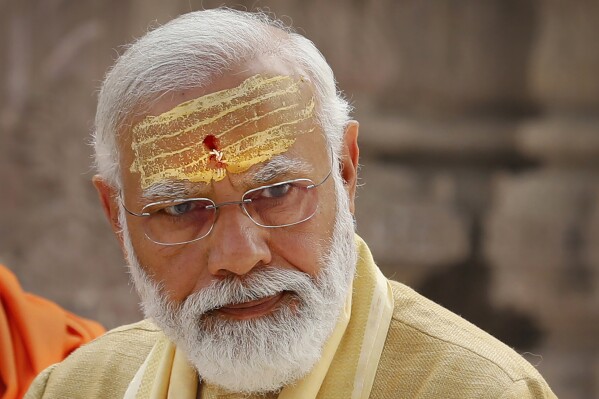 FILE- Indian Prime Minister Narendra Modi has sandalwood paste and vermilion applied on his forehead during the inauguration of Kashi Vishwanath Dham Corridor, a promenade that connects the Ganges River with the centuries-old temple dedicated to Hindu god Shiva in Varanasi, India, Dec. 13, 2021. Hindu nationalism, once a fringe ideology in India, is now mainstream. Nobody has done more to advance this cause than Modi, one of India’s most beloved and polarizing political leaders. (AP Photo/Rajesh Kumar Singh, File)