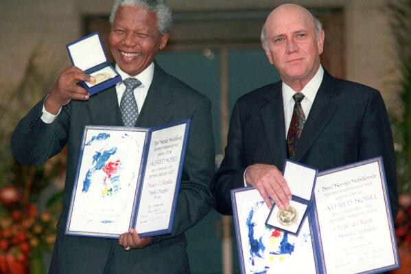 FILE- South African Deputy President F.W. de Klerk, right, and South African President Nelson Mandela pose with their Nobel Peace Prize Gold Medal and Diploma, in Oslo, Dec. 10, 1993. F.W. de Klerk, who oversaw end of South Africa's country’s white minority rule, has died at 85 it was announced Thursday, Nov. 11, 2021. (Jon Eeg/Pool photo via AP, File)