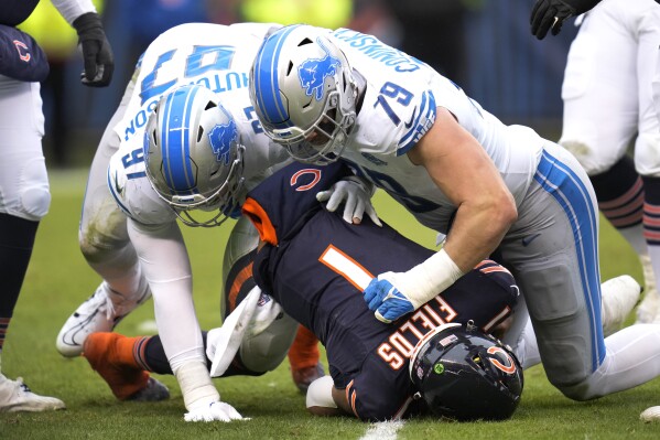 Detroit Lions defensive end Aidan Hutchinson (97) and defensive end John Cominsky (79) sack Chicago Bears quarterback Justin Fields during the first half of an NFL football game Sunday, Dec. 10, 2023, in Chicago. (AP Photo/Erin Hooley)