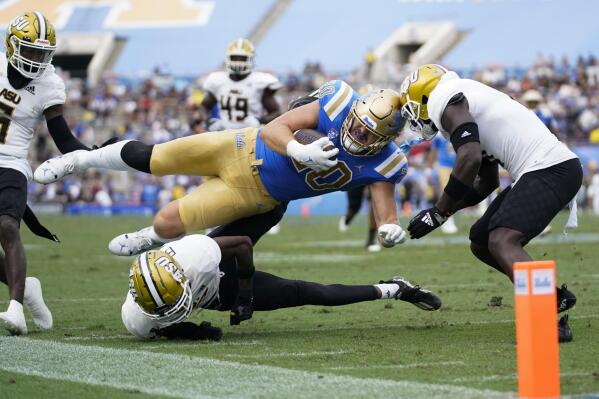 UCLA running back Carsen Ryan (20) is tackled by Alabama State defensive back James Burgess (27) and defensive back Jeffrey Scott Jr. (7) during the first half of an NCAA college football game in Pasadena, Calif., Saturday, Sept. 10, 2022. (AP Photo/Ashley Landis)