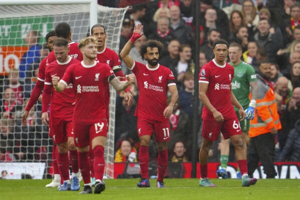 Liverpool players celebrate after Liverpool's Mohamed Salah, centre, scored his side's second goal during the English Premier League soccer match between Liverpool and Everton, at Anfield in Liverpool, England, Saturday, Oct. 21, 2023. (AP Photo/Jon Super)