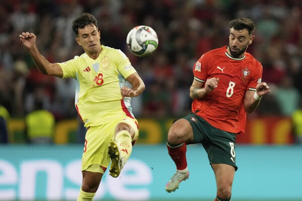Portugal's Bruno Fernandes, right, challenges Spain's Martin Zubimendi during the Nations League final soccer match between Portugal and Spain at the Allianz Arena in Munich, Germany, Sunday, June 8, 2025. (AP Photo/Matthias Schrader)