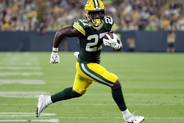 FILE - Green Bay Packers running back Patrick Taylor rushes for a touchdown during the first half of a preseason NFL football game against the New England Patriots, Aug. 19, 2023, in Green Bay, Wis. The Packers boosted their running back depth by welcoming back a couple of familiar faces, as they signed Taylor off the New England Patriots’ practice squad and added James Robinson to their own practice squad. (AP Photo/Matt Ludtke, File)