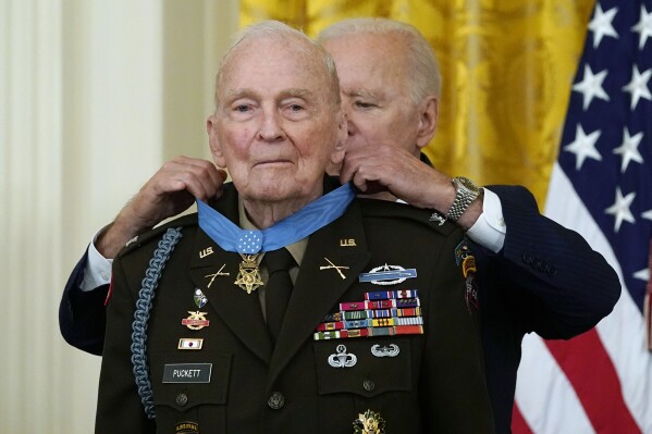 FILE - President Joe Biden presents the Medal of Honor to retired U.S. Army Col. Ralph Puckett, in the East Room of the White House, Friday, May 21, 2021, in Washington. Puckett, a retired Army colonel awarded the Medal of Honor seven decades after he was wounded leading a company of outnumbered Army Rangers in battle during the Korean War, died peacefully Monday, April 8, 2024, at his home in Columbus, Ga., according to the Striffler-Hamby Mortuary, which is handling funeral arrangements. He was 97. (AP Photo/Alex Brandon, File)