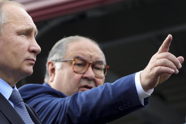 FILE - Russian businessman and founder of USM Holdings, Alisher Usmanov, points while speaking to Russian President Vladimir Putin, left, at the Lebedinsky GOK JSC, in Gubkin, Belgorod Region, Russia, July 14, 2017. The U.S. Treasury Department on April 12, 2023, announced new sanctions aimed at Usmanov, targeting the financial network of one of Russia's wealthiest businessmen. (Mikhail Klimentyev, Sputnik, Kremlin Pool Photo via AP)