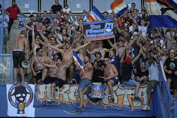 FILE - Montpellier supporters react during the French League One soccer match between Paris Saint-Germain and Montpellier at the Parc des Princes in Paris, on Aug. 13, 2022. A brawl between the coach and a player. Unruly fans throwing an easy match into turmoil. And now a point docked in the standings: Everything seems to be falling apart at French league club Montpellier. (AP Photo/Francois Mori)