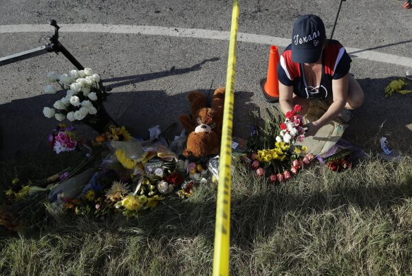 
              Rebecca Thompson places flowers at a makeshift memorial near the scene of a shooting at the First Baptist Church of Sutherland Springs to honor victims, Monday, Nov. 6, 2017, in Sutherland Springs, Texas. A man opened fire inside the church in the small South Texas community on Sunday, killing and wounding many. (AP Photo/Eric Gay)
            
