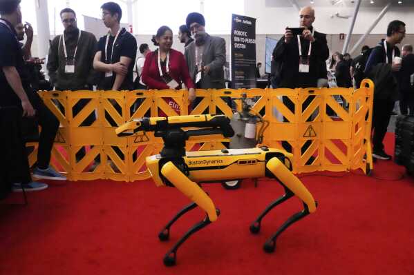 Convention guests watch as a Boston Dynamics robot is demontrated at the Robotics Summit & Expo, Wednesday, April 30, 2025, in Boston. (AP Photo/Charles Krupa)