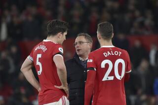 Manchester United's interim manager Ralf Rangnick, center, speaks with Manchester United's Harry Maguire, left, and Manchester United's Diogo Dalot at the end of the English Premier League soccer match between Manchester United and Tottenham Hotspur, at the Old Trafford stadium in Manchester, England, Saturday, March 12, 2022. (AP Photo/Rui Vieira)