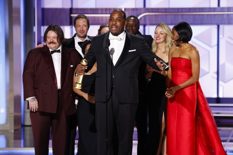 This image released by CBS shows Lionel Boyce, center, with the cast of "The Bear" as they accept the award for best television series - musical or comedy during the 81st Annual Golden Globe Awards in Beverly Hills, Calif., on Sunday, Jan. 7, 2024. (Sonja Flemming/CBS via AP)