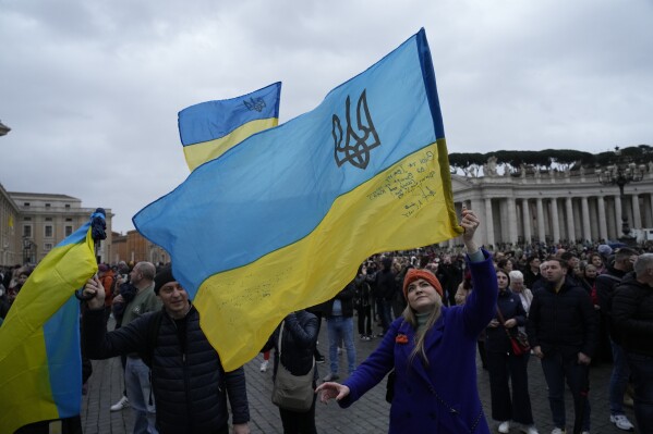 People waves Ukrainian flags before Pope Francis Angelus noon prayer from the window of his studio overlooking St.Peter's Square, at the Vatican, Sunday, March 10, 2024. (AP Photo/Alessandra Tarantino)