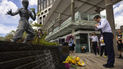 Fans gather in front of the statue of martial artist Bruce Lee to commemorate the 50th anniversary of his death in Hong Kong, Thursday, July 20, 2023. (AP Photo/Louise Delmotte)