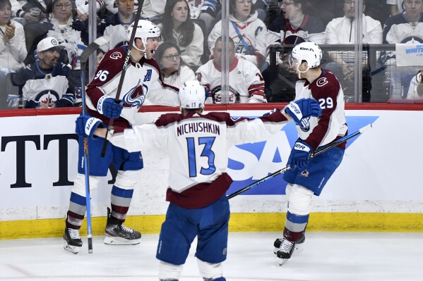 Colorado Avalanche's Mikko Rantanen (96) celebrates his goal with Valeri Nichushkin (13) and Nathan MacKinnon (29) during the third period in Game 5 of an NHL hockey Stanley Cup first-round playoff series against the Winnipeg Jets in Winnipeg, Manitoba, Tuesday, April 30, 2024. (Fred Greenslade/The Canadian Press via AP)
