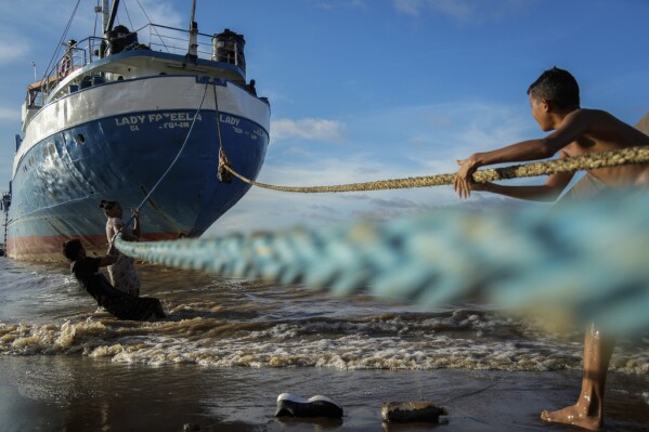 Children play with the ropes of a ship docked on a beach in Parika, Guyana, Sunday, June 9, 2024. (AP Photo/Ramon Espinosa)