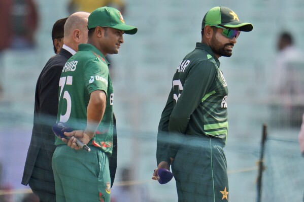 Pakistan's captain Babar Azam, right, and Bangladesh's captain Shakib Al Hasan wait for the coin toss before the ICC Men's Cricket World Cup match between Bangladesh and Pakistan in Kolkata, India, Tuesday, Oct. 31, 2023. (AP Photo/Aijaz Rahi)