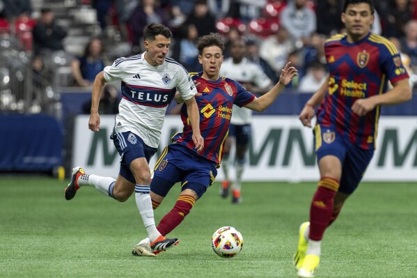 Vancouver Whitecaps' Alessandro Schopf, left, and Real Salt Lake's Fidel Barajas vie for the ball during the first half of an MLS soccer match Saturday, March 23, 2024, in Vancouver, British Columbia. (Ethan Cairns/The Canadian Press via AP)